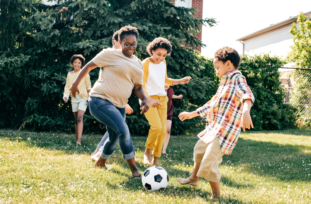 A family playing soccer in their yard